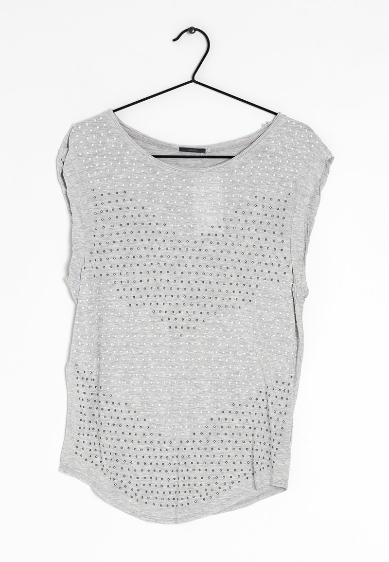 Šedý top s krátkým rukávem a zakulaceným výstřihem, který má texturovaný vzor malých bílých teček a šedých akcentů po celém povrchu.