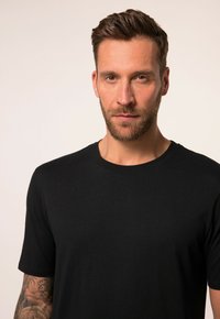 Zwarte T-shirt gemaakt van een zachte stof, met een klassieke ronde hals en korte mouwen. Stevige textuur met minimale zichtbare details.