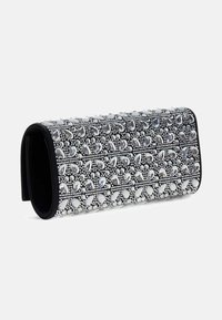Pochette rettangolare nera decorata con numerosi strass trasparenti a forma di goccia e tondi disposti in un motivo simmetrico.
