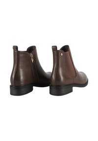 Stivali alla caviglia in pelle marrone con zip laterali e pannelli elastici, tacco basso impilato, punta arrotondata e sottile accentuazione in oro.