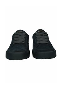 Ein Paar schwarze Wildleder-Sneaker mit dicken schwarzen Schnürsenkeln und dicken Gummisohlen, mit der Marke "Blackstone" auf der Zunge.