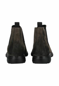 Botines de ante marrón oscuro con paneles laterales elásticos negros y tiradores, mostrados desde la parte trasera sobre un fondo blanco.