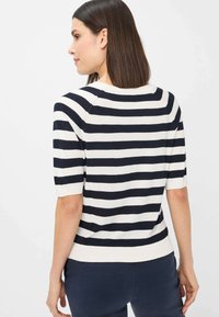 Marineblå og hvid stribet kortærmet strikket sweater med rund halsudskæring og ribbet kant, der fremhæver en blød tekstur og afslappet pasform.