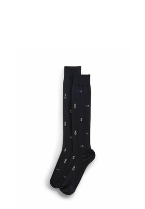 Chaussettes noires montant jusqu'aux genoux avec de petites silhouettes colorées de personnages en bâtons et les mots "MEILLEUR PAPA" brodés en répétition.