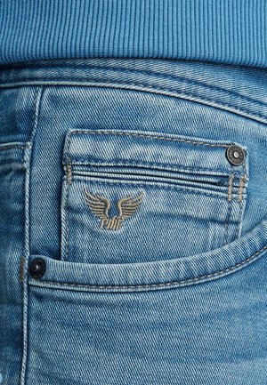 Lichtblauwe denim jeans met een achterzak met een geborduurd vleugellogo en een zwart knoopdetail. De stof heeft een vervaagde textuur.