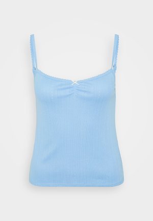 Camiseta sin mangas de color azul claro con tirantes finos y ajustables, escote en forma de ondas y un pequeño lazo decorativo en el centro. Textura suave y acanalada.