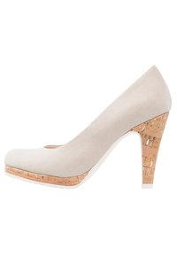 Beige suede high heel shoe with a rounded toe, featuring a cork accent on the platform and heel, and a smooth white sole.