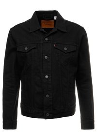 Svart denimjacka med knäppning framtill, spetsig krage, två bröstfickor och långa ärmar. Slät textur med mörka sömnadsdetaljer.