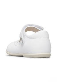 Scarpa in pelle bianca con punta tondeggiante, cinturino alla caviglia e dettagli a taglio decorativi. Presenta una suola morbida e un piccolo accento a forma di bottone.