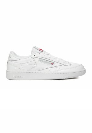 Białe niskie sneakersy Reebok z zapięciem na sznurówki, perforowanym przodem oraz logo Reebok z brytyjską flagą na bocznej części i podeszwie.