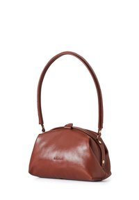 Bolso de mano de cuero marrón con forma redondeada, textura suave y un solo asa curvada. Presenta un logo sutil y detalles de herrajes en latón.