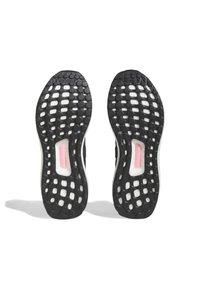 Μαύρες καουτσού�κ σόλες παπουτσιών με υφή κυψέλης, διαθέτοντας μια λευκή μεσαία σόλα και ένα ροζ μαξιλάρι. Το λογότυπο εμφανές στην επιφάνεια.