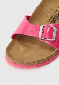 Roze gepatenteerde leren sandaal met een verstelbare gesp, een zachte kurken voetbed en een gestructureerde roze buitenzool.