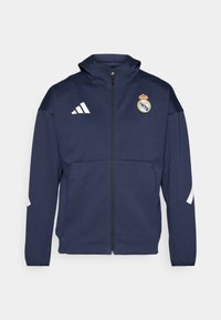 Marineblaues Zip-Up-Jackett mit Kapuze, mit weißem Adidas-Logo und Real Madrid-Wappen. Hergestellt aus glattem Stoff mit Seitentaschen.