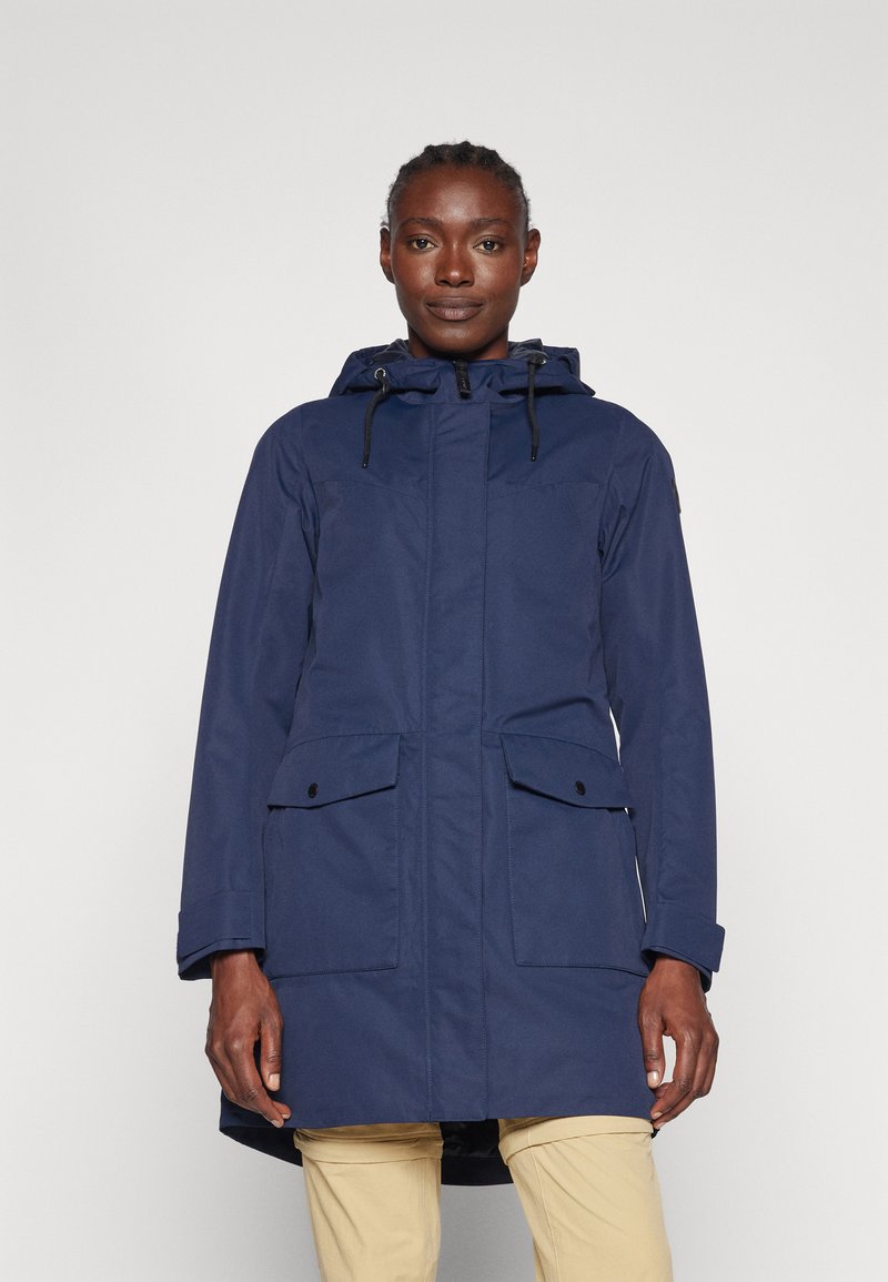 Parka impermeabile blu navy con cappuccio, due tasche frontali con pattina, chiusura frontale con zip e un orlo posteriore leggermente più lungo per una copertura aggiuntiva.