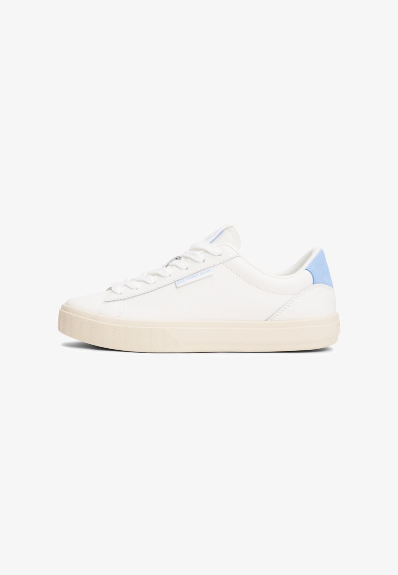 Hvite lavt opp sneakers med en glatt lær-overdel, lyseblå hæl-accenter og teksturert såle. Har seks øyeskader og minimal merkevare.