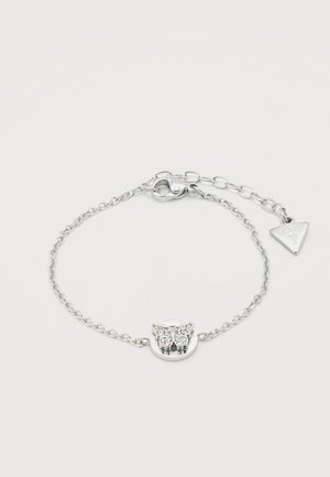 Bracelet en chaîne argentée avec un pendentif papillon orné de petits cristaux clairs et un fermoir ajustable avec une étiquette triangulaire.