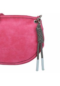 Bolso de ante fucsia brillante con costuras negras contrastantes, que presenta una correa trenzada en blanco y negro y acentos en azul claro en los extremos.