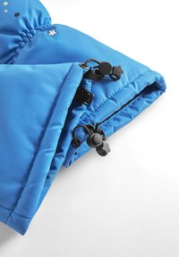 Niebieska kurtka ocieplana z elastycznymi mankietami, posiada czarne troczki i akcent w kształcie gwiazdy. Gładka powierzchnia z detalami szycia.