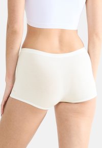 Shorts hipster bianchi in cotone con una texture liscia, una cintura elastica ampia e un logo minimale sul lato.