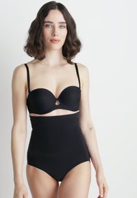 Zwarte bikini-top met beugels en verstelbare bandjes, gecombineerd met hoge zwarte onderkant met een gladde textuur.