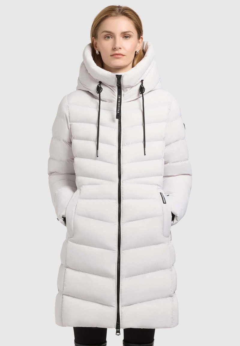 Long white puffer coat with a high, padded collar, black zipper, and drawstrings. Features horizontal quilted sections and side pockets.