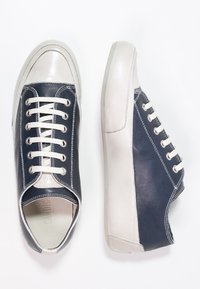 Sneaker in pelle navy e grigia con una texture liscia, punta rotonda, lacci bianchi e pannellatura a contrasto sui lati. Suola in gomma.