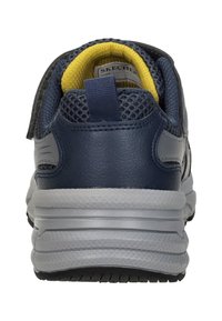 Marineblauwe sportschoen met een bovenkant van mesh en synthetisch materiaal. Gele binnenvoering, gepolsterde kraag en grijze zool met een gestructureerd grippatroon.