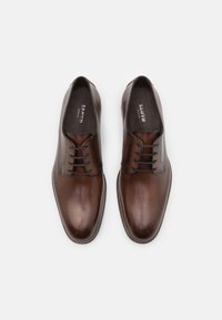 Chaussures habillées en cuir marron avec une texture lisse, bout arrondi, design classique à lacets et détails de surpiqûre subtils sur le dessus.