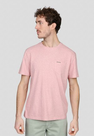 T-shirt à manches courtes rose clair avec un col rond, présentant une poche sur la poitrine gauche et un logo subtilement brodé dans une teinte plus foncée.
