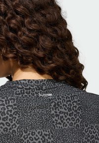 Czarny t-shirt z nadrukiem w panterkę na całej powierzchni, z okrągłym dekoltem i metką "CLIMACOOL" z tyłu.