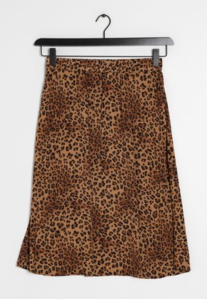 Jupe marron longueur genou avec motif léopard noir suspendue à un cintre noir sur fond blanc.