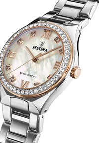 Reloj de pulsera en tono plateado con esfera de nácar, acentos en oro rosa y bisel de cristal. Presenta números romanos y funcionalidad de energía solar.