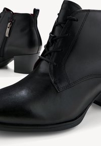 Stivali alla caviglia in pelle nera con un design elegante, dotati di lacci e cerniera laterale. Tacco a blocco e texture liscia, con cuciture dettagliate.