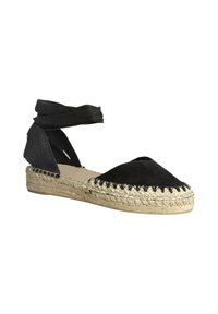 Espadrilles negras con parte superior de ante, suela de yute trenzado y diseño de envoltura en el tobillo. Presenta detalles de costura a lo largo de la puntera y un tacón texturizado.