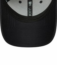 Schwarze Baseballmütze mit einer glatten, strukturierten Krone und einem gebogenen Schirm. Das Innere zeigt ein hellgraues Futter mit bedruckten Details.