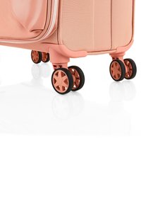 Maleta rígida rosa con textura suave, cuatro ruedas multidireccionales y un doble zip para un acceso fácil.