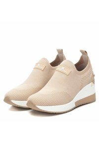 Zapatillas de cuña de punto beige con upper texturizado, suela blanca y un sutil logo en el lateral. Diseño sin cordones con dos tiradores.