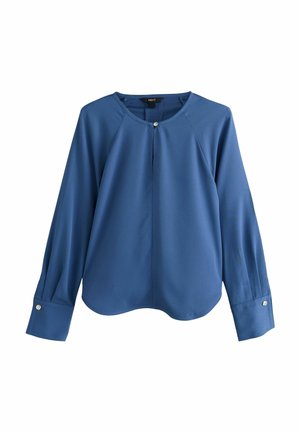 Blouse bleue à manches longues avec encolure ronde, détail d’un seul bouton au col et aux poignets, et ourlet arrondi, présentée sur fond blanc.