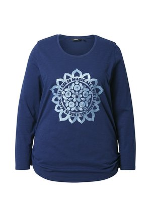Maglietta a maniche lunghe blu navy realizzata in tessuto morbido, con una stampa circolare di mandala con accenti argentati e testo in un carattere decorativo.