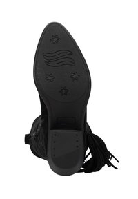 Sohle eines schwarzen Stiefels mit spitzer Zehe, die eine strukturierte Griffigkeit mit Sternformen und Wellenmuster zeigt, sowie einen Absatz mit kleinen runden Vertiefungen.