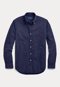 Camicia blu navy a maniche lunghe con bottoni e colletto, con logo rosso ricamato sul petto sinistro, distesa su sfondo bianco.