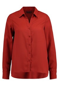 Chemise rouge boutonnée, en tissu lisse, avec un col pointu, des manches longues et un ourlet droit légèrement plus long à l'arrière.