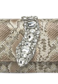 Kopertówka w wzór skóry węża w odcieniach beżu, z ozdobnym zapięciem w postaci klejnotu, ozdobionym wieloma przezroczystymi i srebrnymi cyrkoniami, tworzącymi chropowatą powierzchnię.