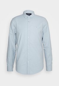 Ljusblå långärmad skjorta med knappar i en bomullsblandning, med en knapp-ner krage, subtil logo på bröstet och en slät textur.