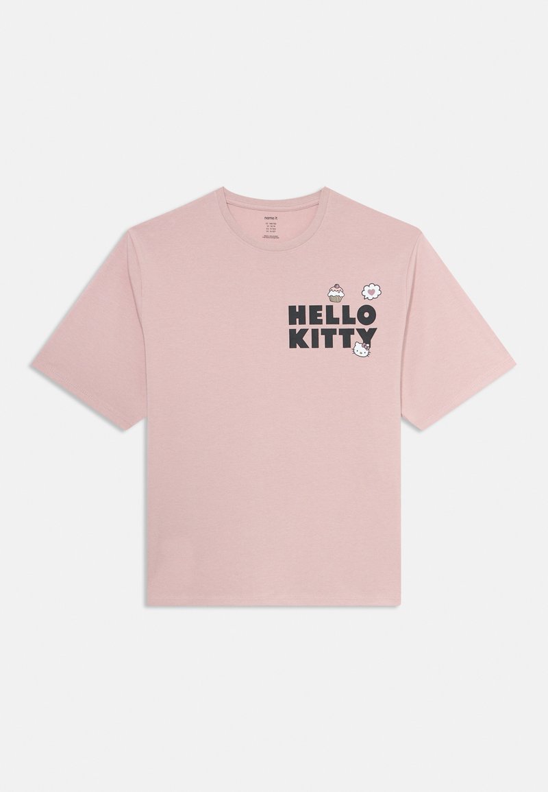 Gaiši rozā T-krekls ar "HELLO KITTY" tekstu, mazu kēksu, ziedu un Hello Kitty seju kreisajā krūšu daļā.