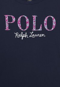 T-shirt blu navy con la scritta "POLO" ricamata in fiori rosa e "Ralph Lauren" in bianco, realizzata in morbido cotone.