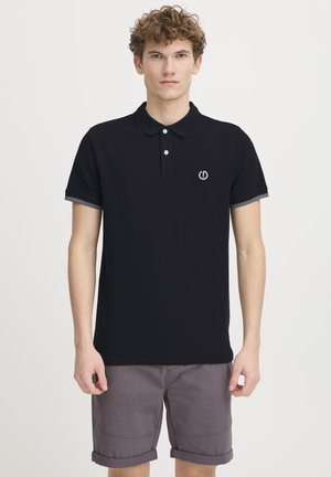 Camisa polo negra con cuello, con una tapeta de botones y un ribete gris en las mangas. Pequeño logo centrado en el pecho.