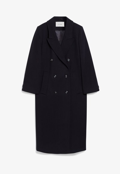 Casaco azul-marinho de peito duplo, feito de uma mistura de lã, com lapelas largas, quatro bolsos frontais e três botões pretos na frente.