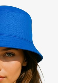 Blauwe emmerhoed met gestructureerde stof, brede rand en een gevormde kroon. Heeft strakke lijnen en geen zichtbare hardware of patronen.
